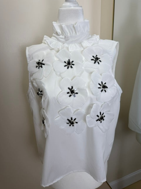 White sleeveless blouse with black and white accent flowers